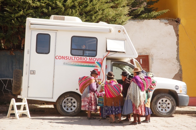 A group of Quechua women waiting for appointments at a "Consultorio Movil" (mobile clinic) in a lakeside town in Bolivia.